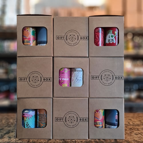 Corporate Gifts of craft beer in boxes displayed on an oak table