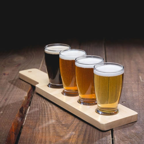 Tasting glasses filled with craft beer displayed on an oak table